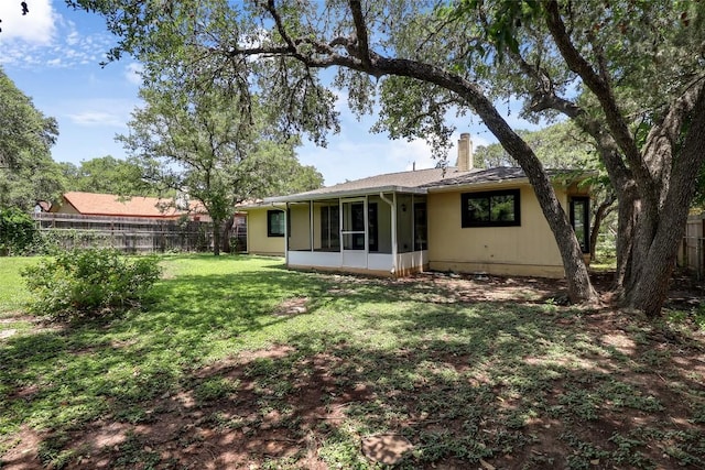 1928 Ramona Cir, San Marcos, TX 78666 - back of house featuring a chimney, a fenced backyard, and a sunroom