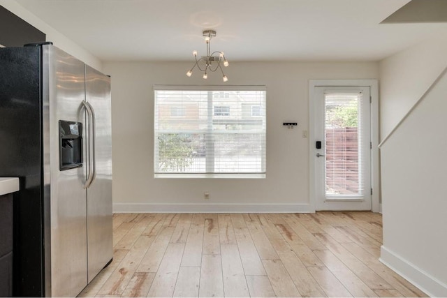 1101 Grove Blvd Unit 102, Austin, TX 78741 - unfurnished dining area with light wood-style floors and a chandelier