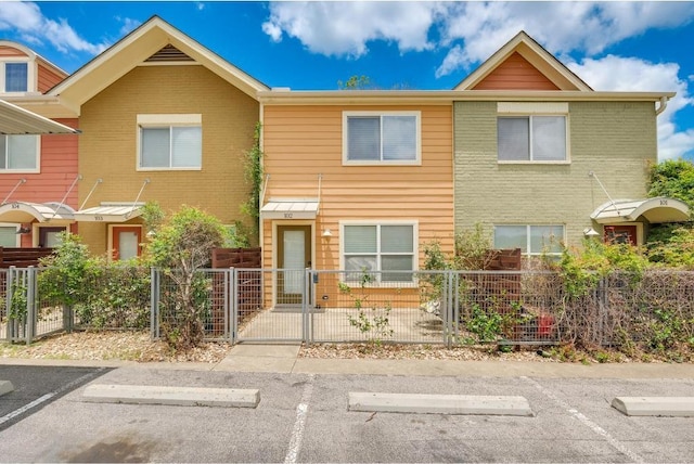 1101 Grove Blvd Unit 102, Austin, TX 78741 - view of property with a fenced front yard, uncovered parking, and a gate