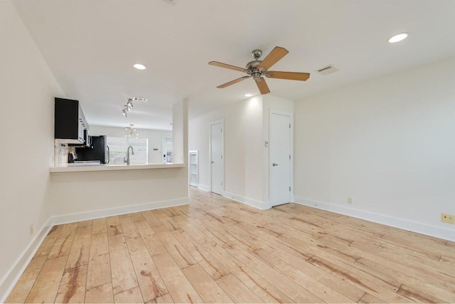 1101 Grove Blvd Unit 102, Austin, TX 78741 - unfurnished living room with light wood finished floors, a ceiling fan, recessed lighting, and rail lighting
