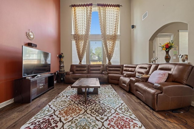 614 Spanish Mustang Dr, Cedar Park, TX 78613 - living area featuring arched walkways, a high ceiling, and dark wood-type flooring