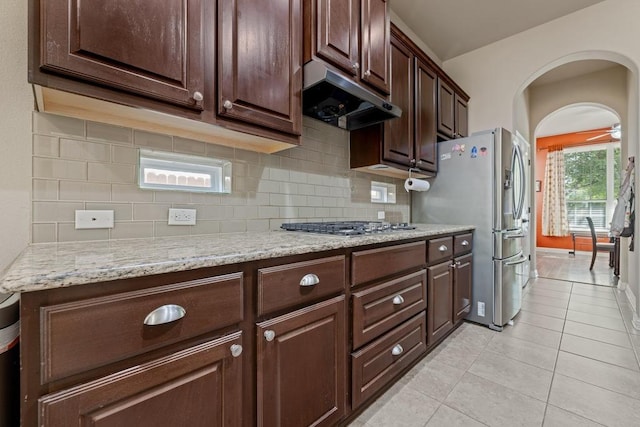 614 Spanish Mustang Dr, Cedar Park, TX 78613 - kitchen with under cabinet range hood, appliances with stainless steel finishes, tasteful backsplash, and light tile patterned floors