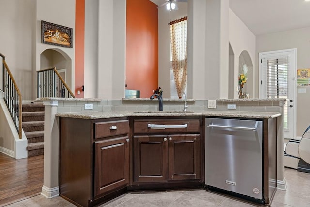 614 Spanish Mustang Dr, Cedar Park, TX 78613 - kitchen featuring stainless steel dishwasher, dark brown cabinetry, light stone counters, a ceiling fan, and an island with sink