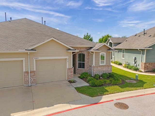 14405 Frankel Loop Unit 34A, Pflugerville, TX 78660 - view of front of home with brick siding, a garage, driveway, a front yard, and roof with shingles