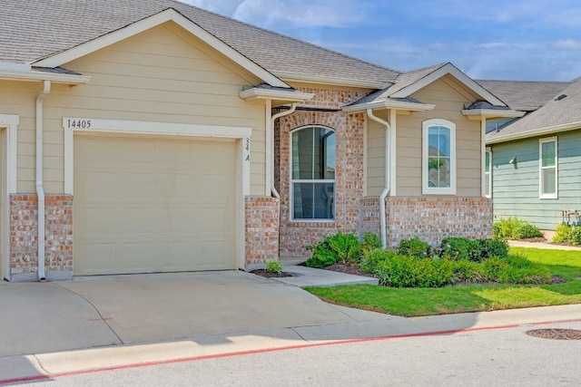14405 Frankel Loop Unit 34A, Pflugerville, TX 78660 - view of front of house featuring driveway, brick siding, and a garage
