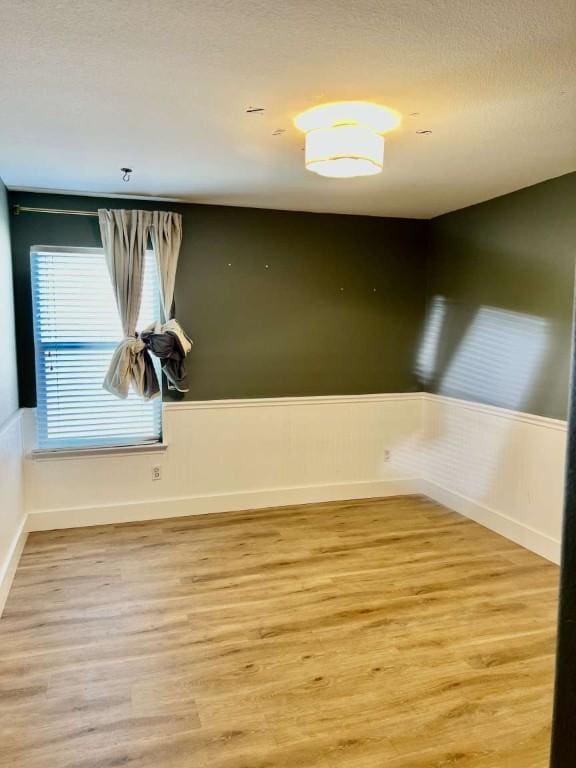 2118 Howell Mountain Dr, Cedar Park, TX 78613 - unfurnished room with light wood-type flooring, wainscoting, and a textured ceiling