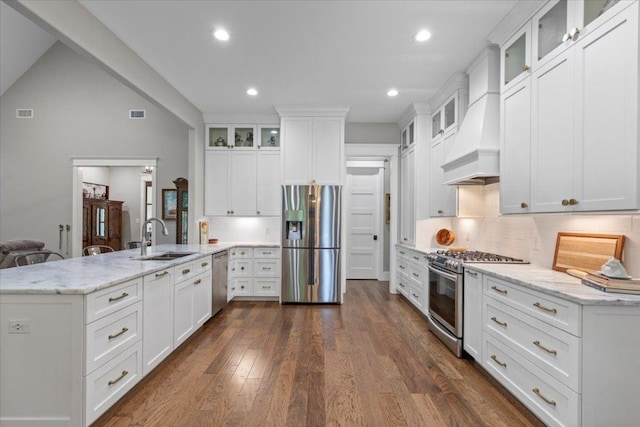 1307 Fm 969, Bastrop, TX 78602 - kitchen featuring stainless steel appliances, a peninsula, dark wood-style flooring, tasteful backsplash, and light stone countertops