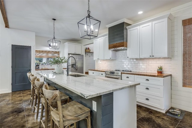 20008 Victoria Chase Rd, Lago Vista, TX 78645 - kitchen featuring appliances with stainless steel finishes, a chandelier, tasteful backsplash, white cabinets, and a breakfast bar area