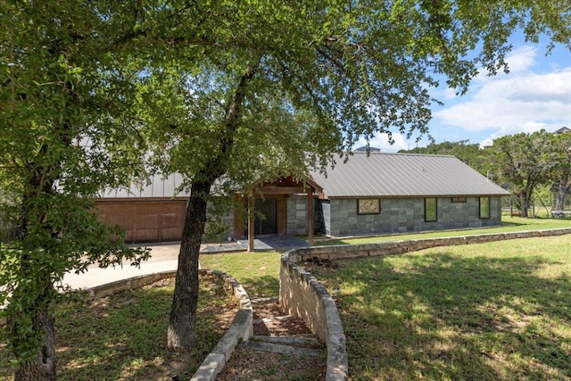 2817 Tradewind Dr, Spicewood, TX 78669 - mid-century home with a garage, stone siding, and a front lawn