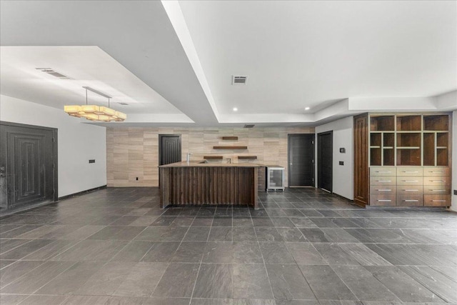 2817 Tradewind Dr, Spicewood, TX 78669 - unfurnished living room featuring a raised ceiling, wine cooler, and recessed lighting