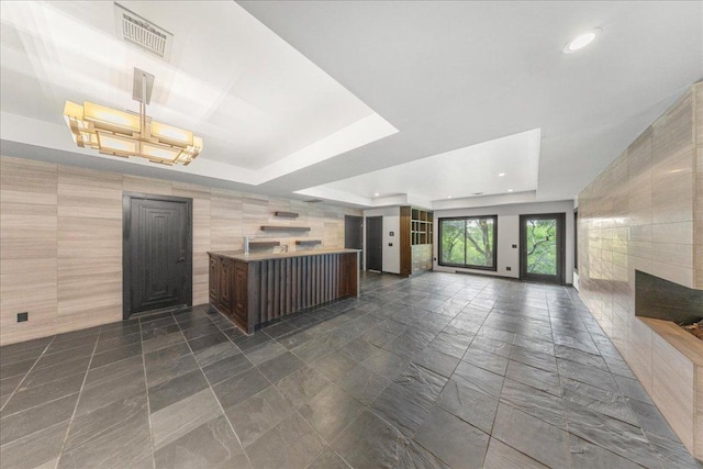 2817 Tradewind Dr, Spicewood, TX 78669 - kitchen featuring a raised ceiling, open floor plan, tile walls, recessed lighting, and a center island