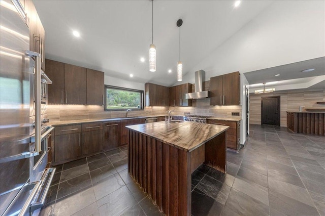 2817 Tradewind Dr, Spicewood, TX 78669 - kitchen with wall chimney range hood, fridge, tasteful backsplash, decorative light fixtures, and a center island with sink