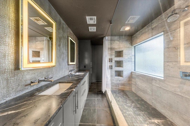 2817 Tradewind Dr, Spicewood, TX 78669 - bathroom featuring double vanity, tiled shower, and tile patterned floors