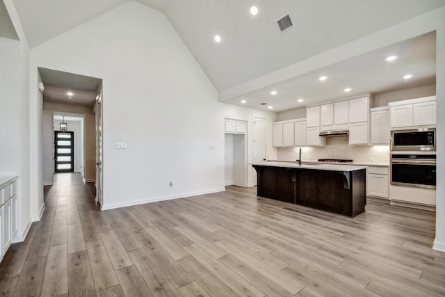 564 Biscayne Bay Bnd, Kyle, TX 78640 - kitchen featuring stainless steel appliances, high vaulted ceiling, light countertops, white cabinetry, and recessed lighting
