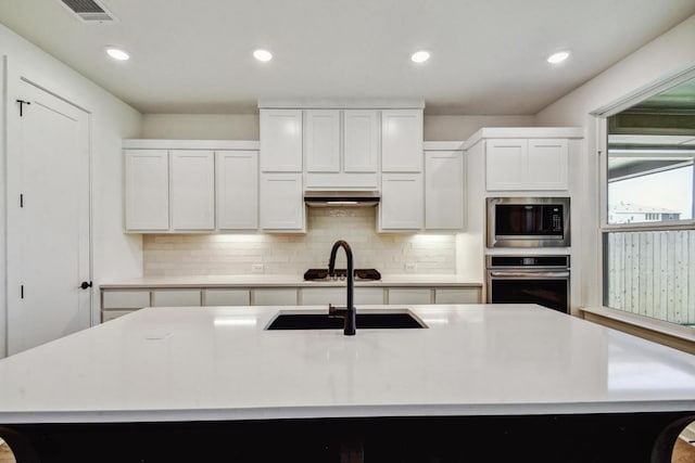 564 Biscayne Bay Bnd, Kyle, TX 78640 - kitchen with appliances with stainless steel finishes, decorative backsplash, light countertops, recessed lighting, and white cabinets