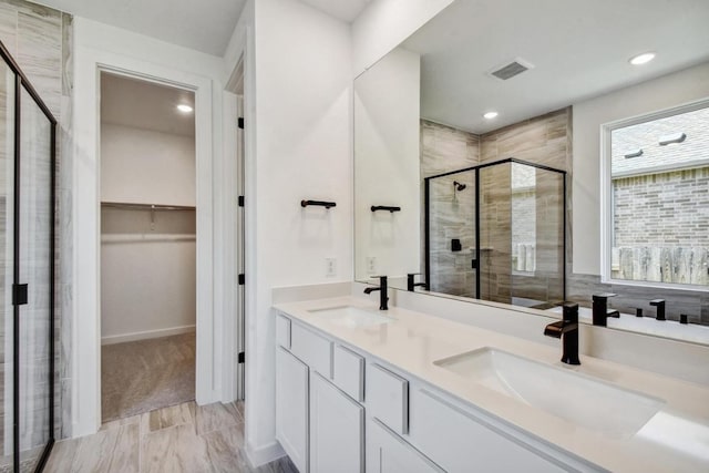564 Biscayne Bay Bnd, Kyle, TX 78640 - bathroom featuring a stall shower, a spacious closet, double vanity, and recessed lighting