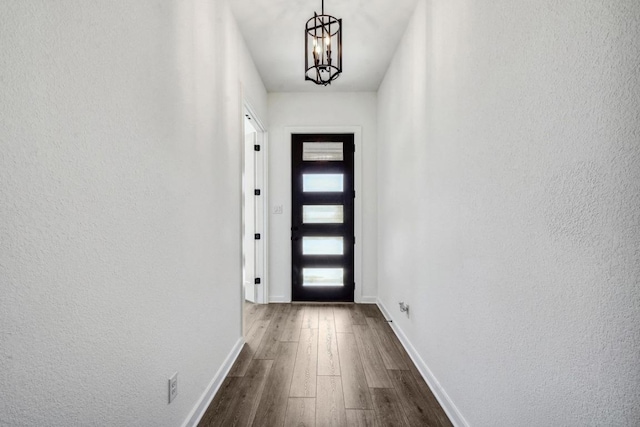 564 Biscayne Bay Bnd, Kyle, TX 78640 - doorway to outside with dark wood-style floors, a chandelier, and a textured wall