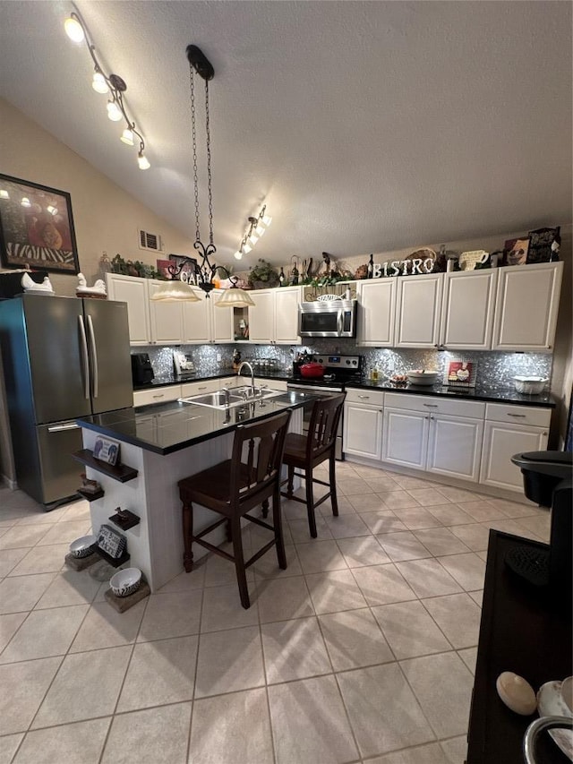 746 Pecan Ln, Cottonwood Shores, TX 78657 - kitchen with stainless steel appliances, vaulted ceiling, dark countertops, a textured ceiling, and backsplash