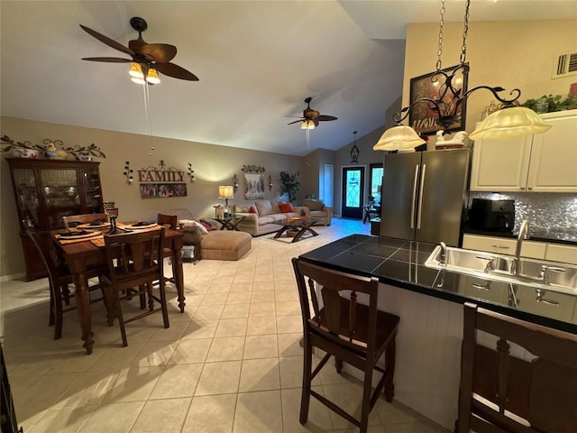 746 Pecan Ln, Cottonwood Shores, TX 78657 - kitchen featuring freestanding refrigerator, ceiling fan, dark countertops, lofted ceiling, and a kitchen breakfast bar