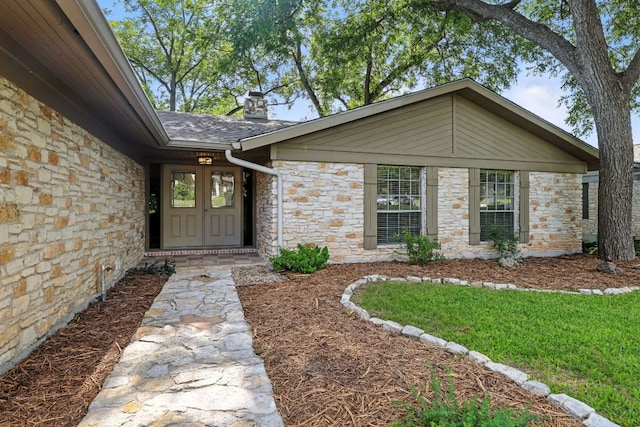 11915 River Oaks Trl, Austin, TX 78753 - entrance to property featuring stone siding, a chimney, and a shingled roof
