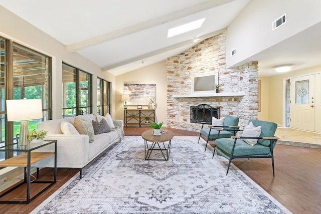 11915 River Oaks Trl, Austin, TX 78753 - living room with wood finished floors, a stone fireplace, a skylight, beam ceiling, and high vaulted ceiling