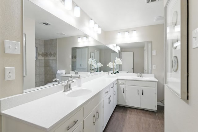 11915 River Oaks Trl, Austin, TX 78753 - bathroom with double vanity, wood finished floors, and a tile shower