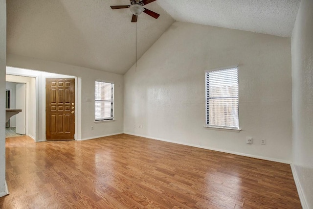 1000 Milford Way, Austin, TX 78745 - unfurnished living room featuring a ceiling fan, wood finished floors, and high vaulted ceiling