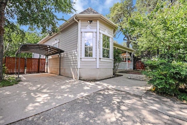 2211 Wilson St, Austin, TX 78704 - view of home's exterior featuring a detached carport and concrete driveway