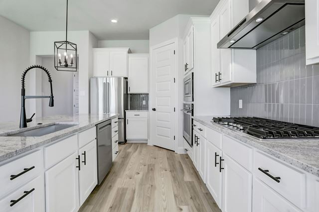 17309 Howdy Way, Manor, TX 78653 - kitchen with wall chimney range hood, stainless steel appliances, light wood-type flooring, white cabinetry, and recessed lighting