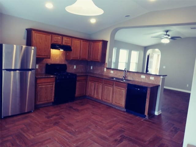 3304 Wickham Ln, Austin, TX 78725 - kitchen with black appliances, arched walkways, under cabinet range hood, vaulted ceiling, and a peninsula