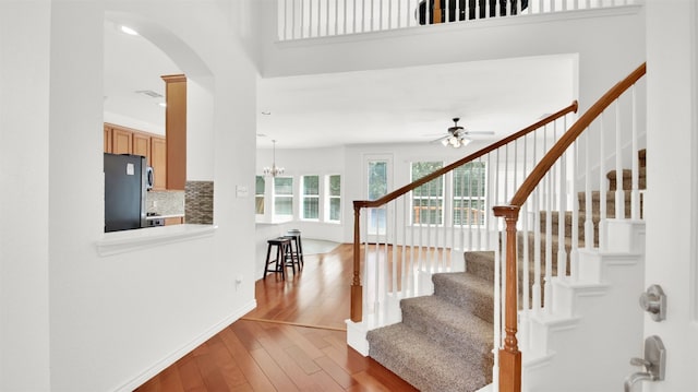 2310 Dervingham Dr, Cedar Park, TX 78613 - staircase featuring wood finished floors, arched walkways, ceiling fan, and a chandelier
