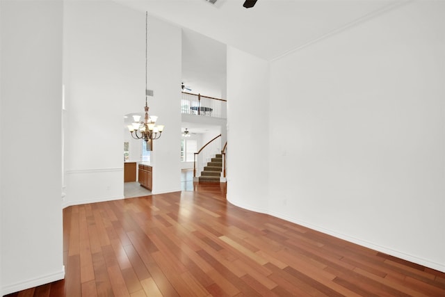 2310 Dervingham Dr, Cedar Park, TX 78613 - unfurnished room with ceiling fan, a chandelier, stairs, light wood-style floors, and a high ceiling