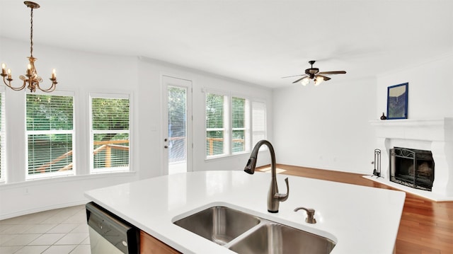 2310 Dervingham Dr, Cedar Park, TX 78613 - kitchen with open floor plan, stainless steel dishwasher, light countertops, a fireplace, and pendant lighting