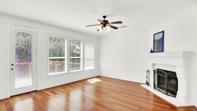 2310 Dervingham Dr, Cedar Park, TX 78613 - unfurnished living room featuring wood finished floors, a ceiling fan, a fireplace with raised hearth, and crown molding