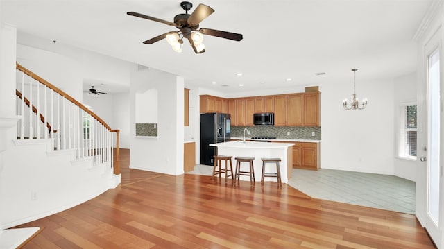 2310 Dervingham Dr, Cedar Park, TX 78613 - kitchen with black refrigerator with ice dispenser, stainless steel microwave, light countertops, a ceiling fan, and recessed lighting