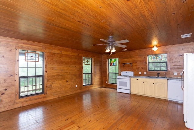 2874 Fm 1704, Elgin, TX 78621 - kitchen featuring white appliances, wooden ceiling, wood walls, a ceiling fan, and healthy amount of natural light
