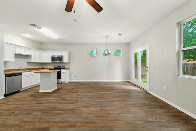 2911 Pops Way Unit 50, Austin, TX 78745 - kitchen featuring appliances with stainless steel finishes, white cabinets, dark wood-type flooring, a center island, and ceiling fan