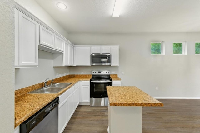 2911 Pops Way Unit 50, Austin, TX 78745 - kitchen with stainless steel appliances, dark wood-type flooring, white cabinetry, and a center island