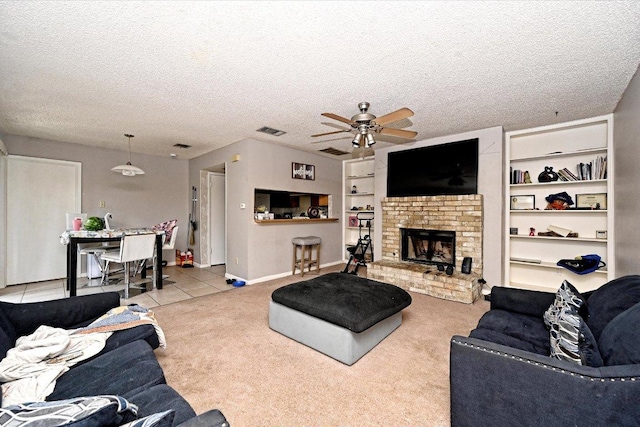 7825 Beauregard Cir Unit 25, Austin, TX 78745 - tiled living area with a ceiling fan, carpet flooring, a textured ceiling, a brick fireplace, and built in features