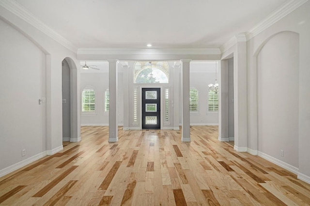 501 Flamingo Blvd, Lakeway, TX 78734 - foyer entrance with ornate columns, light wood finished floors, a chandelier, ornamental molding, and arched walkways