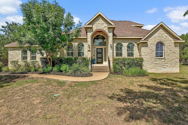 501 Flamingo Blvd, Lakeway, TX 78734 - view of front facade featuring stone siding, a front yard, and roof with shingles