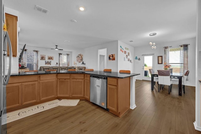 4909 Teverola Dr, Round Rock, TX 78665 - kitchen featuring stainless steel appliances, open floor plan, wood finished floors, plenty of natural light, and recessed lighting