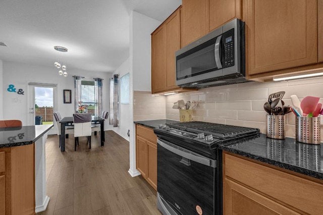 4909 Teverola Dr, Round Rock, TX 78665 - kitchen with stainless steel appliances, backsplash, wood finished floors, and dark stone countertops