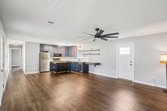 755 E Bellville St, Giddings, TX 78942 - unfurnished living room featuring ceiling fan and dark wood-style flooring