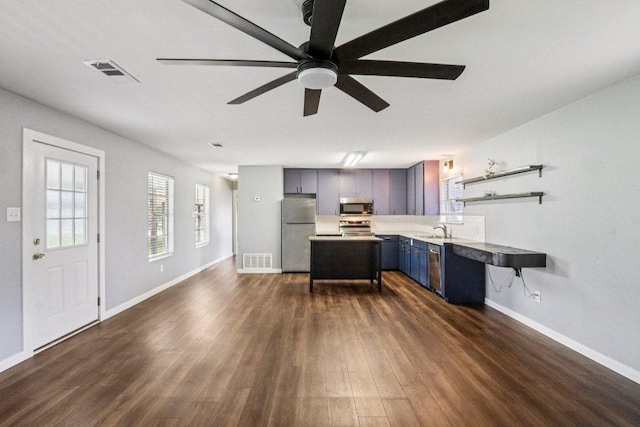 755 E Bellville St, Giddings, TX 78942 - kitchen featuring stainless steel appliances, dark wood-style floors, a ceiling fan, open shelves, and light countertops