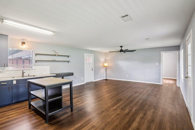 755 E Bellville St, Giddings, TX 78942 - kitchen featuring blue cabinetry, a ceiling fan, and dark wood-style floors