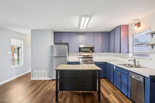 755 E Bellville St, Giddings, TX 78942 - kitchen with stainless steel appliances, blue cabinetry, dark wood-type flooring, and light countertops