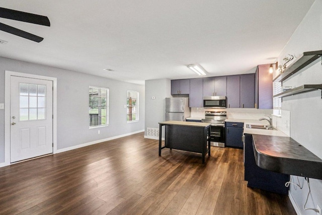 755 E Bellville St, Giddings, TX 78942 - kitchen with appliances with stainless steel finishes, dark wood-type flooring, and light countertops