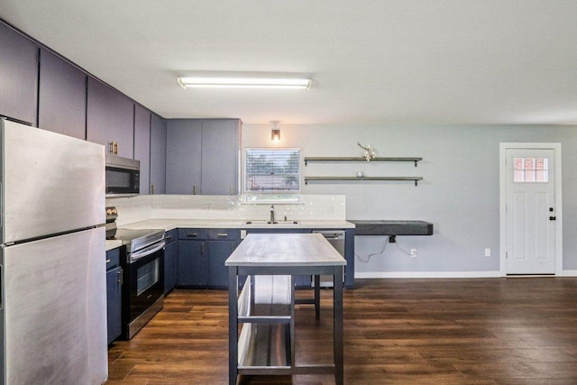 755 E Bellville St, Giddings, TX 78942 - kitchen featuring appliances with stainless steel finishes, dark wood-type flooring, and light countertops