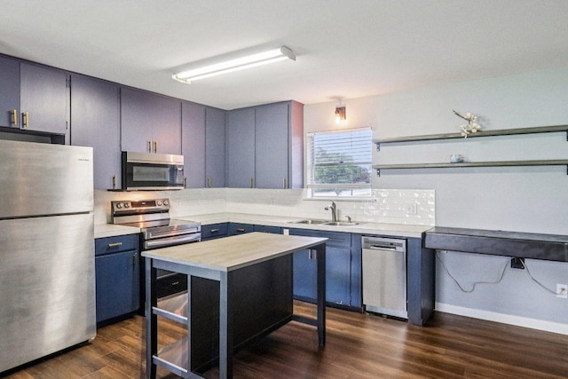 755 E Bellville St, Giddings, TX 78942 - kitchen with stainless steel appliances, backsplash, blue cabinets, light countertops, and dark wood-style flooring